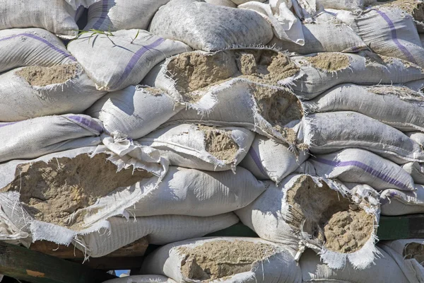 torn sandbags arranged around historical monuments and roadblocks during martial law in Ukraine with a piece of sky. War in Ukraine