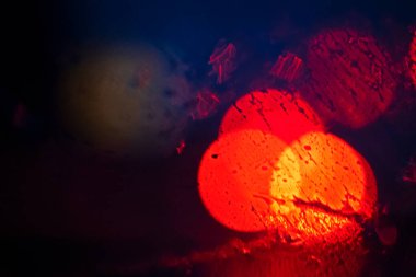 blurry abstract multicolored red highlights from the included stops in bad rainy weather at night