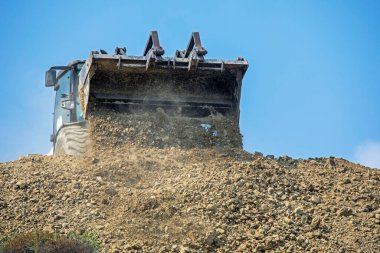 escalator bucket pours out clay soil. Global construction. Mining.