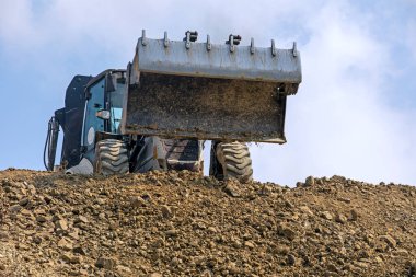 huge bucket of an escalator against the background of the sky with clouds. Global construction. Mining.