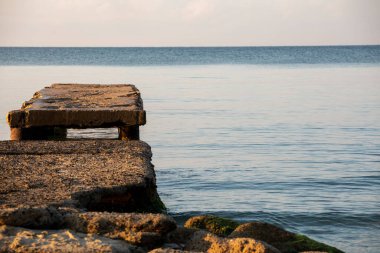 stone jetty in the early sunny morning on the marble sea. Family holiday.