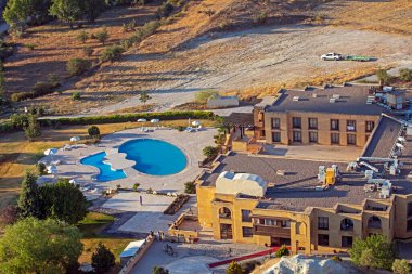 hotel with swimming pool and sun loungers top view on a summer day, family vacation