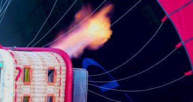 inflate a balloon with a flame of gas from the inside before flying in the sky in the early morning before dawn, tourist