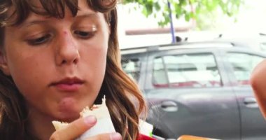 Genç kız teneffüste taze pişmiş shawarma yer. Okul kahvaltısı, sokak yemeği.