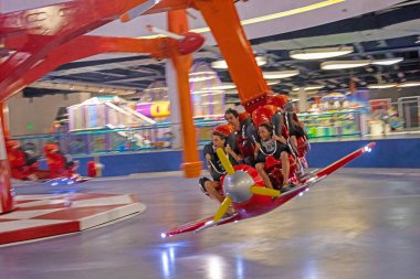 happy family rides on an extreme amusement plane flipping in the air. Active family vacation