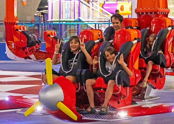happy family before riding on an extreme amusement plane turning upside down in the air. Active family vacatio
