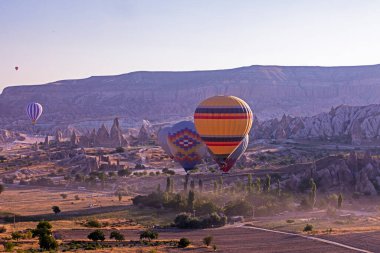 Sabahın erken saatlerinde Goreme Kapadokya Vadisi 'nde güneşe karşı uçan sıcak hava balonlarının güzel manzarası.