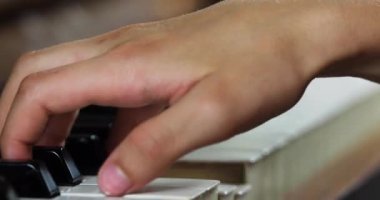  Küçük piyanist sağ eli piyanoda, yatay olarak pratik yapıyor.