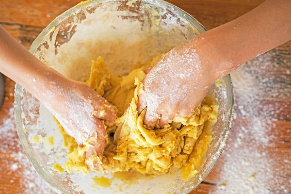 girl\'s hands stir the soft cookie dough in a bowl on the table. Cooking cookies for the holidays.