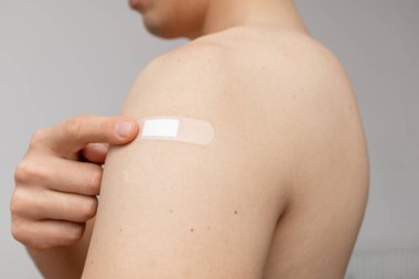 Omzundaki yamayı gösteren mutlu adam.