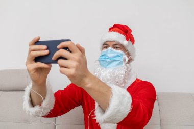 Noel Baba gibi giyinmiş video konferansı aracılığıyla konuşuyor.