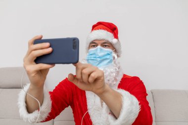 Noel Baba gibi giyinmiş video konferansı aracılığıyla konuşuyor.