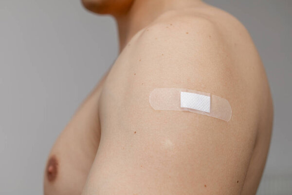 Man with patch on the shoulder fragment of the body