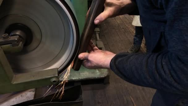 Blacksmith sharpening the knife on grinding stone — Stock Video