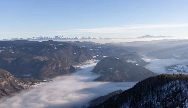 Schneebedeckte Berggipfel und nebliges Tal — Stockfoto