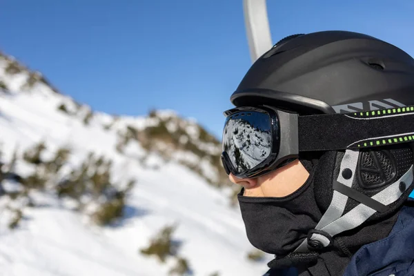 Лыжный курорт человек на подъемнике в шлеме и маске — стоковое фото