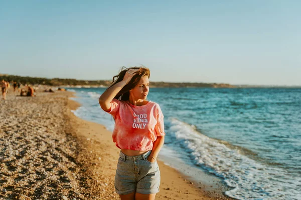 Μια Νεαρή Όμορφη Γυναίκα Περπατά Κατά Μήκος Της Παραλίας Και — Φωτογραφία Αρχείου