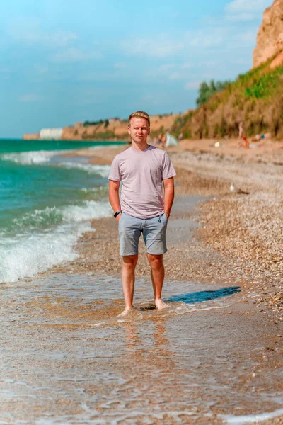 Egy Fiatal Szőke Férfi Sétál Parton Azúrkék Óceán Vagy Tenger — Stock Fotó