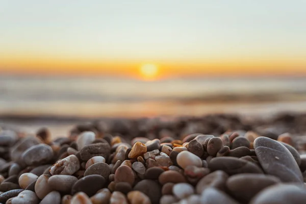 Gün Batımında Sakin Bir Sahil Planda Güzel Desenli Çakıl Taşları — Stok fotoğraf