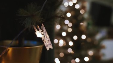 Oturma odasında çelenklerle süslenmiş güzel bir Noel ağacı. Sıcak bir kış akşamı. 4k video.
