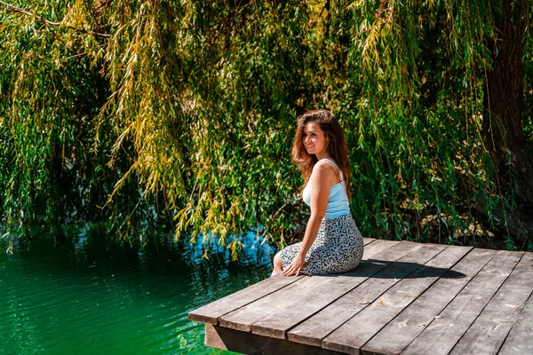 Urocza Młoda Kobieta Spódnicy Siedzi Drewnianym Moście Tle Natury Jeziorem — Zdjęcie stockowe