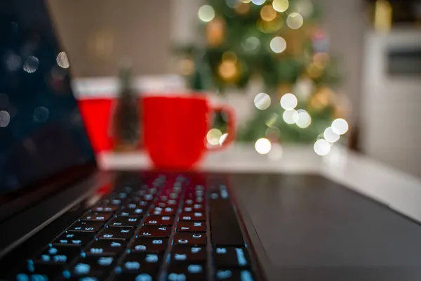 クリスマスツリーの背景とラップトップキーボードの選択的フォーカス — ストック写真