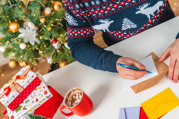 Giovane Con Maglione Firma Cartoline Scrive Lettere Vicino Albero Natale — Foto Stock