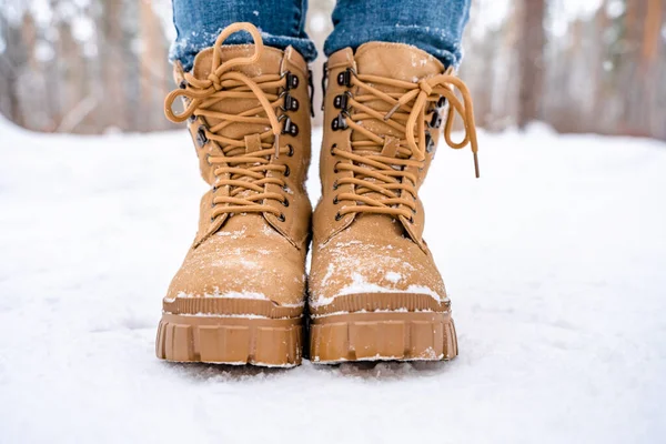 雪の森の中の雪の中の黄色のブーツの女性の足 — ストック写真