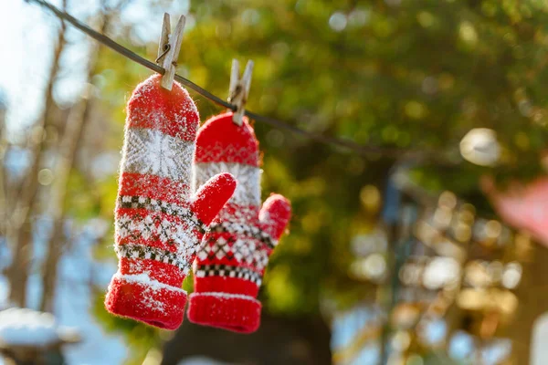 Czerwone Rękawice Dziane Zakurzone Śniegiem Wiszą Drewnianych Szpilkach Tle Zimowego — Zdjęcie stockowe