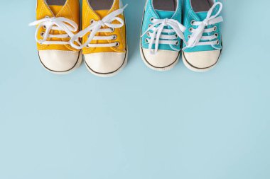 Bebeğin renkli arka plandaki küçük spor ayakkabıları. Bebek beklemenin ve bebekle seyahat etmenin konsepti, çocuk yaşam tarzı. Uzayı kopyala, düz yat