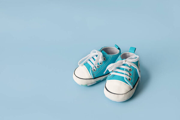 Baby's little sneakers on a colorful background. The concept of waiting for a baby and the concept of traveling with baby, children's lifestyle. Copy space, flat lay