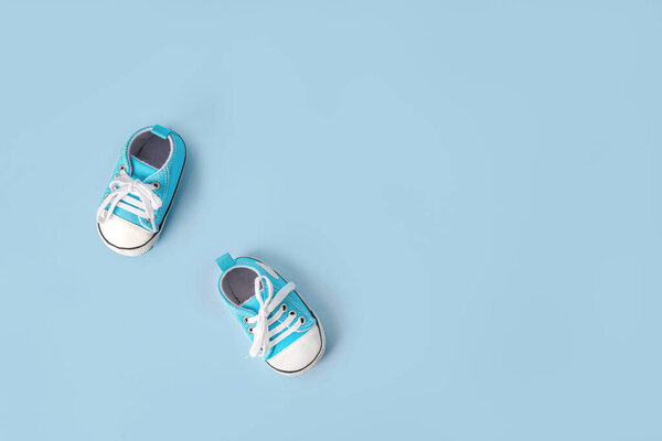 Baby's little sneakers on a colorful background. The concept of waiting for a baby and the concept of traveling with baby, children's lifestyle. Copy space, flat lay