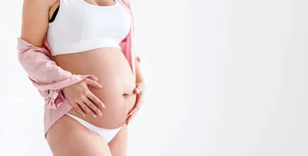 Pembe Gömlekli Hamile Bir Kadın Beyaz Arka Planda Koca Göbeğine — Stok fotoğraf