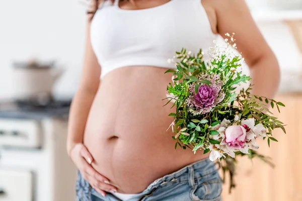一个穿着白衣的孕妇手持美丽的花朵 可爱的概念健康怀孕 母亲节 母亲节的概念 带有复制空间的横幅 — 图库照片