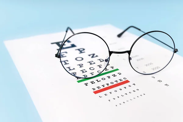Uma Mesa Para Verificar Visão Óculos Sobre Fundo Azul Claro — Fotografia de Stock