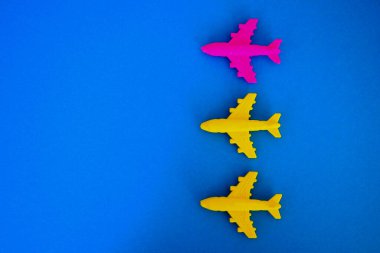 Renkli arka planda oyuncak uçaklar ve tıbbi maskeler. 