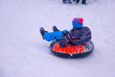 Bulutlu bir günde, kış parkında yürüyen insanlar. 