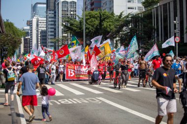 PAULO, BRAZIL - 23 Ekim 2022, güneşli Pazar, insanlar Avenida Paulista 'da günün tadını çıkarıyorlar ve Brezilya cumhurbaşkanı adaylarını desteklemek için bayraklarını taşıyorlar..