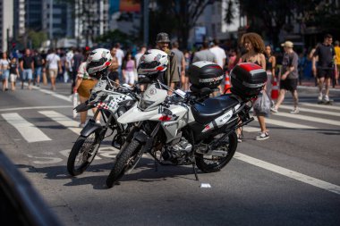 PAULO, BRAZIL - 23 Ekim 2022, güneşli Pazar, insanlar Avenida Paulista 'da günün tadını çıkarıyorlar ve Brezilya cumhurbaşkanı adaylarını desteklemek için bayraklarını taşıyorlar..