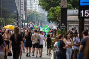 PAULO, BRAZIL - 23 Ekim 2022, güneşli Pazar, insanlar Avenida Paulista 'da günün tadını çıkarıyorlar ve Brezilya cumhurbaşkanı adaylarını desteklemek için bayraklarını taşıyorlar..