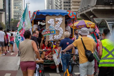 PAULO, BRAZIL - 23 Ekim 2022, güneşli Pazar, insanlar Avenida Paulista 'da günün tadını çıkarıyorlar ve Brezilya cumhurbaşkanı adaylarını desteklemek için bayraklarını taşıyorlar..