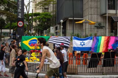 PAULO, BRAZIL - 23 Ekim 2022, güneşli Pazar, insanlar Avenida Paulista 'da günün tadını çıkarıyorlar ve Brezilya cumhurbaşkanı adaylarını desteklemek için bayraklarını taşıyorlar..