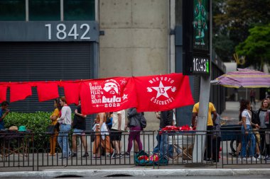 PAULO, BRAZIL - 23 Ekim 2022, güneşli Pazar, insanlar Avenida Paulista 'da günün tadını çıkarıyorlar ve Brezilya cumhurbaşkanı adaylarını desteklemek için bayraklarını taşıyorlar..