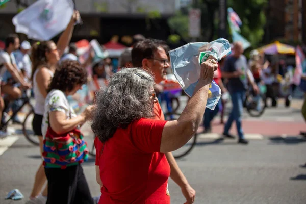 PAULO, BRAZIL - 23 Ekim 2022, güneşli Pazar, insanlar Avenida Paulista 'da günün tadını çıkarıyorlar ve Brezilya cumhurbaşkanı adaylarını desteklemek için bayraklarını taşıyorlar..