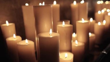 Bir sürü parafin mumları yakın planda yanıyor..