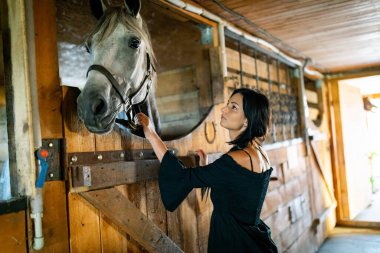 Kırsalda uzun siyah saçlı bir kız. Atlı Ipadrome. Kırsal alanlar, vahşi batı..
