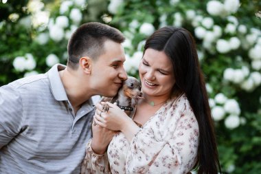 Parktaki mutlu Ukraynalı çift. Küçük köpek, güzel bir buket lale. bahar tazeliği