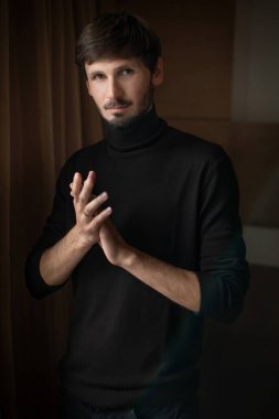 Sakallı bir adamın etkileyici yakın plan portresi. Doğal ışık. koyu arkaplan