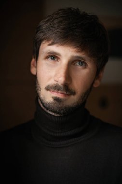 Sakallı bir adamın etkileyici yakın plan portresi. Doğal ışık. koyu arkaplan