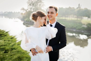 İnanılmaz gülümseyen bir düğün çifti. Memnun gelin ve şık damat..